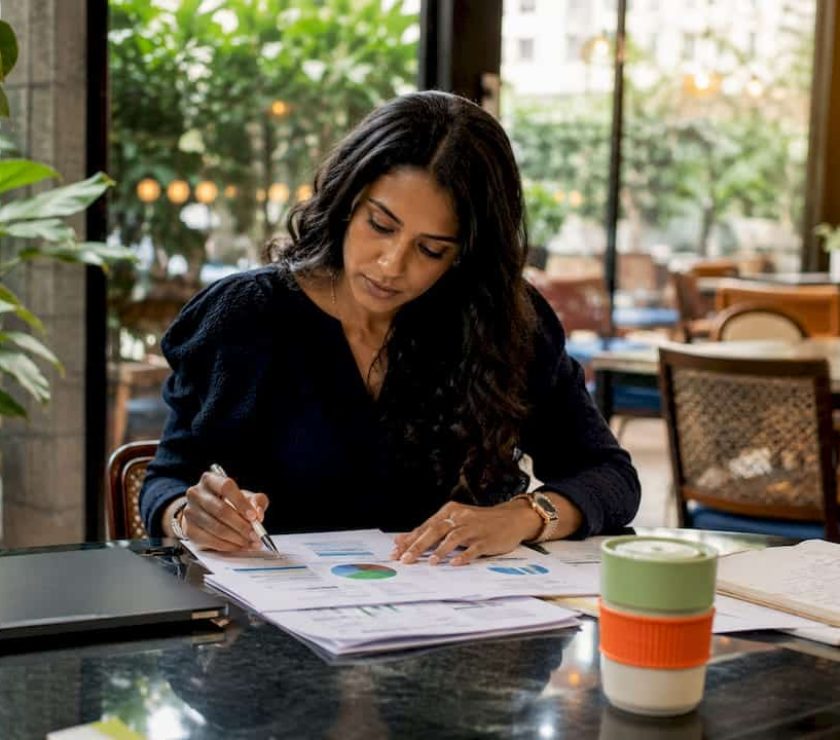 Woman reviewing PPC campaign documents at desk