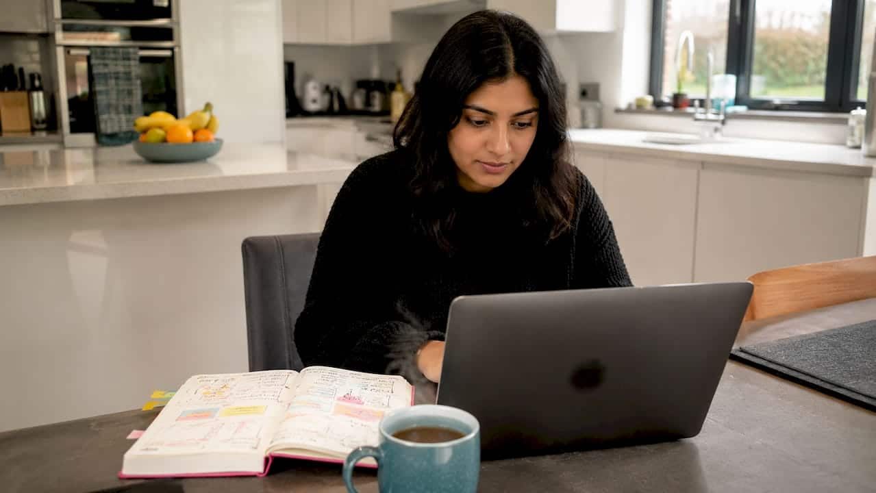 UK businesswoman setting up Google Ads on laptop at home
